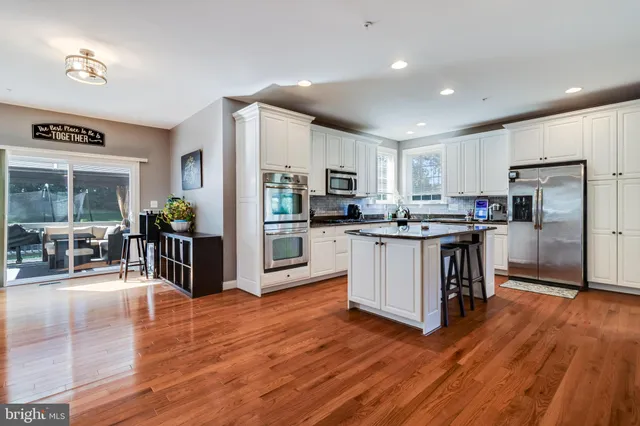 a kitchen with granite countertop white cabinets stainless steel appliances and a window