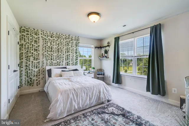 a bedroom with a bed dresser and a flat tv screen