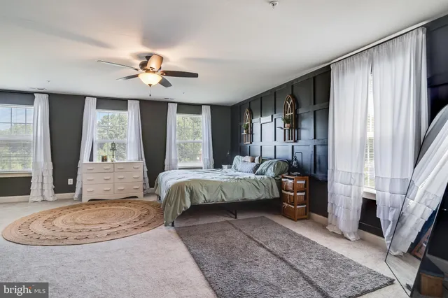 a spacious bedroom with a bed and a chandelier