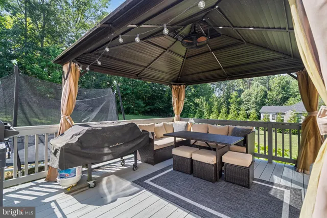 a view of a patio with table and chairs under an umbrella with a small yard