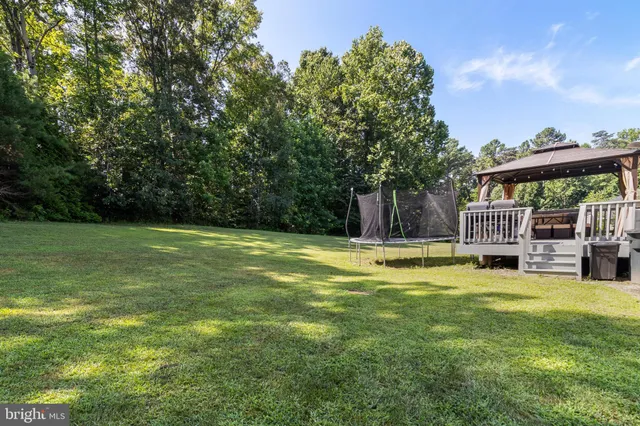 a view of a house with a big yard and a large tree