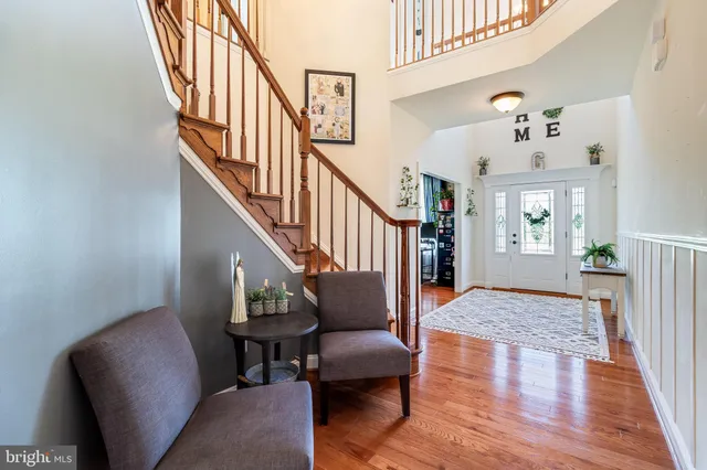 a living room with wooden floor and a stairs