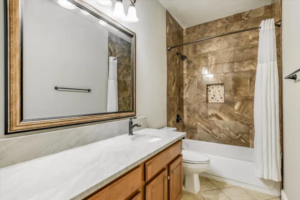 a bathroom with a granite countertop sink a toilet and shower