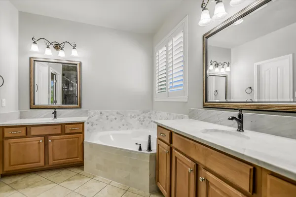 a bathroom with a tub sink and mirror