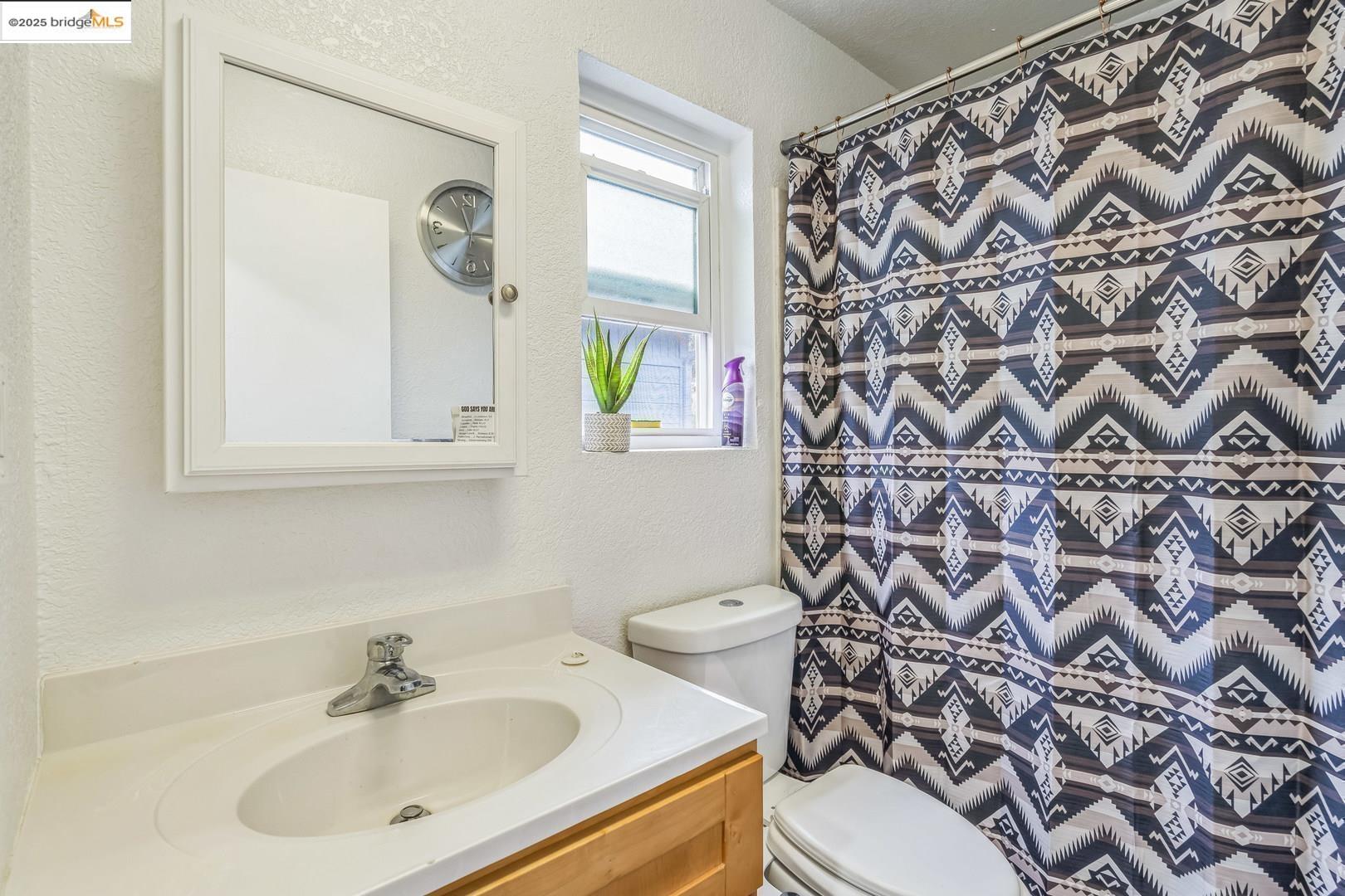 874 Pine Street Oakland, CA 94607 - Photo 19 of 32 a bathroom with a sink and mirror with toilet