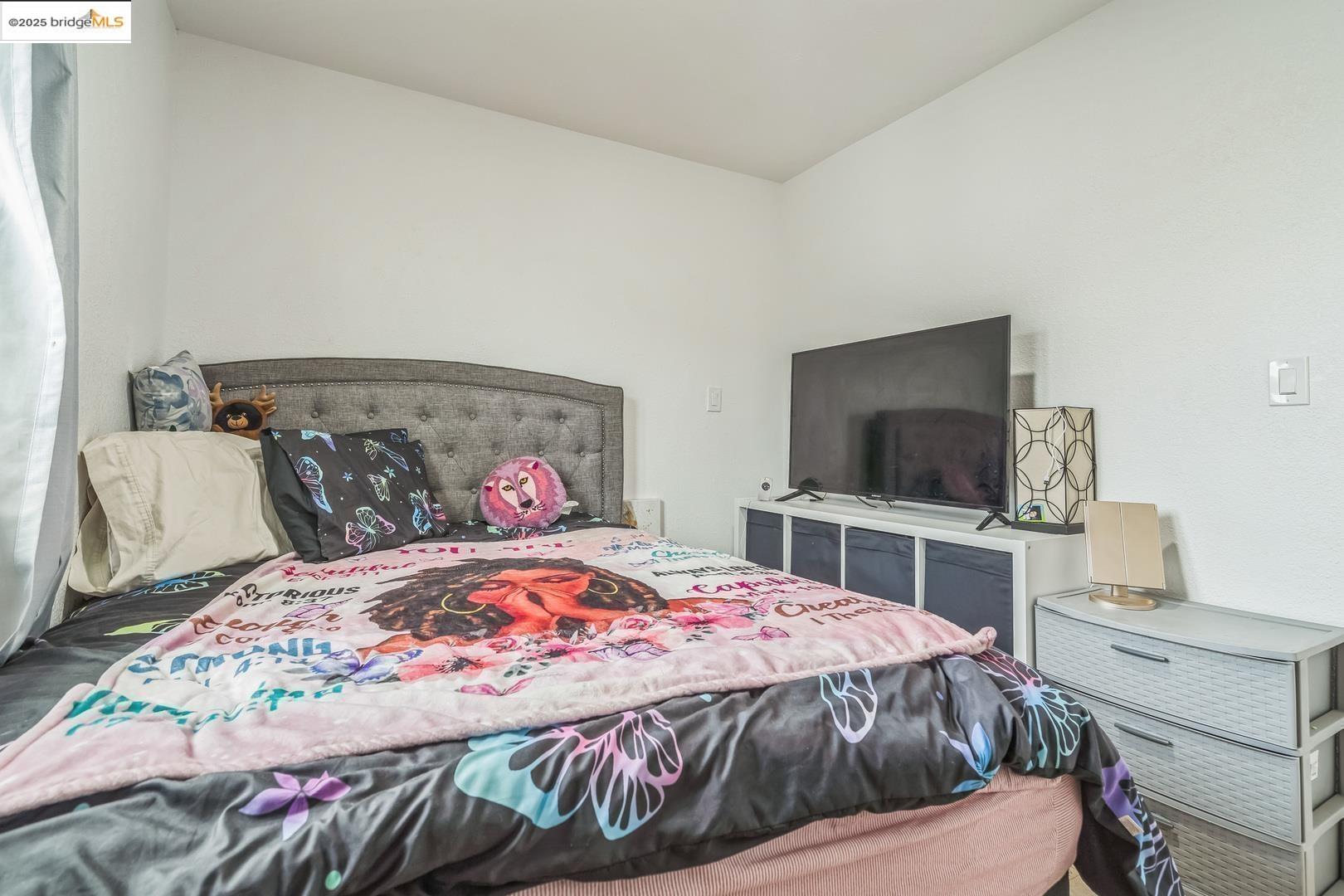 874 Pine Street Oakland, CA 94607 - Photo 21 of 32 a bedroom with a bed and a flat screen tv