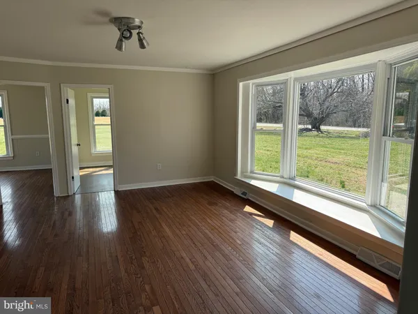 a view of a room with wooden floor and windows