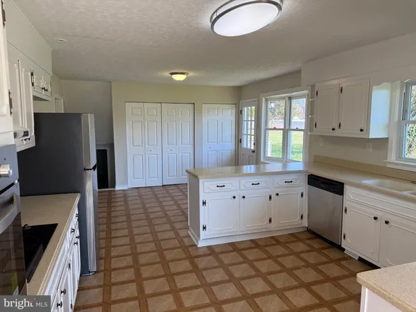 a kitchen with stainless steel appliances a stove a sink and a refrigerator