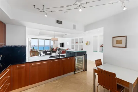 a large kitchen with stainless steel appliances kitchen island granite countertop a refrigerator and a stove top oven