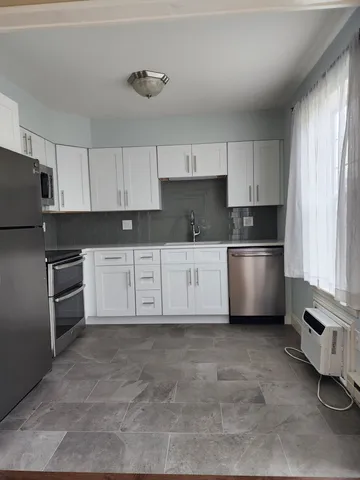 a kitchen with stainless steel appliances and white cabinets