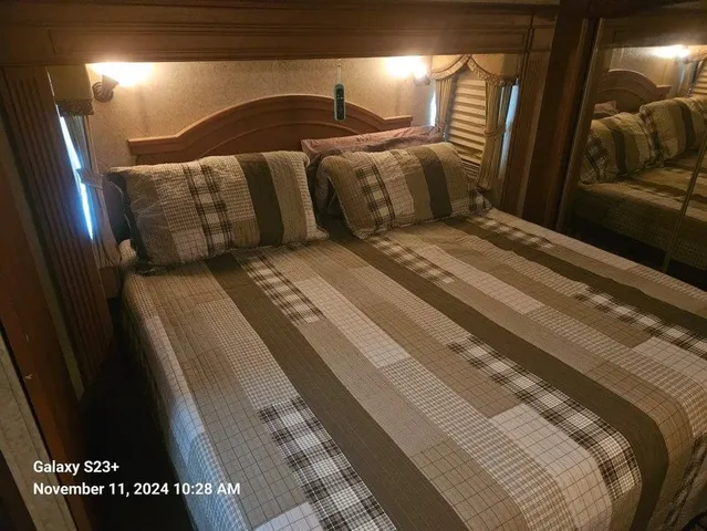 a large bed sitting in a bedroom next to a window