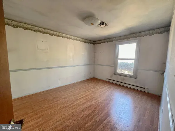 a view of an empty room with window and bathroom