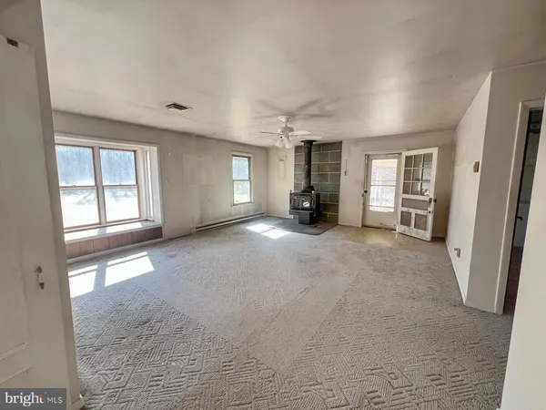 an empty room with windows and closet