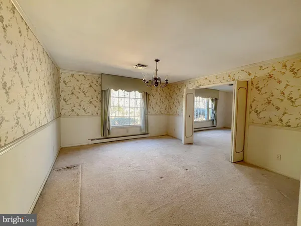 a view of a big room with windows and chandelier fan