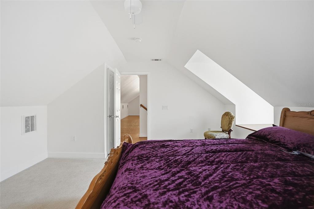 11805 Osprey Avenue Weeki Wachee, FL 34614 - Photo 23 of 34 a bedroom with a large bed and a chandelier