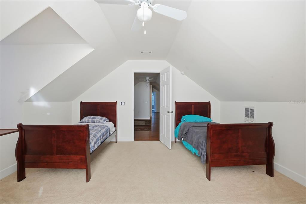 11805 Osprey Avenue Weeki Wachee, FL 34614 - Photo 29 of 34 a bedroom with a bed and a chandelier