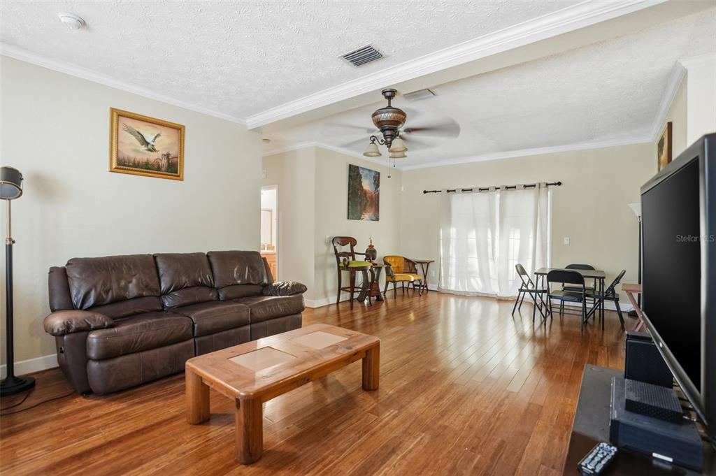 11805 Osprey Avenue Weeki Wachee, FL 34614 - Photo 3 of 34 a living room with furniture wooden floor and a flat screen tv
