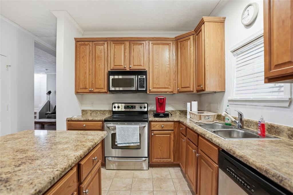 11805 Osprey Avenue Weeki Wachee, FL 34614 - Photo 9 of 34 a kitchen with stainless steel appliances granite countertop a sink stove and microwave