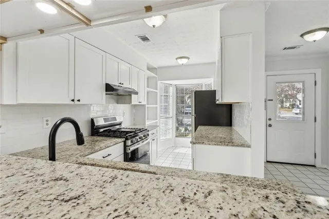 a kitchen with a refrigerator and a stove top oven