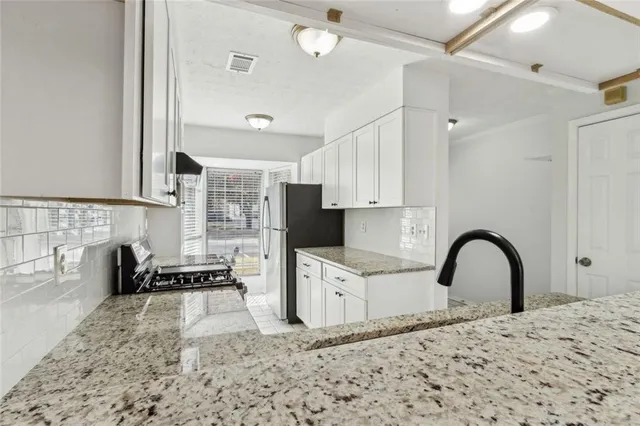 a kitchen with granite countertop a sink stainless steel appliances and cabinets