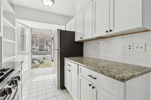 a kitchen with a stove a sink and cabinets