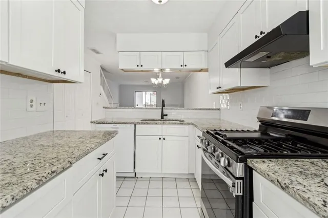 a view of a kitchen sink a faucet a microwave and stove in it