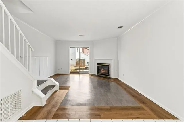 an empty room with fireplace wooden floor and windows