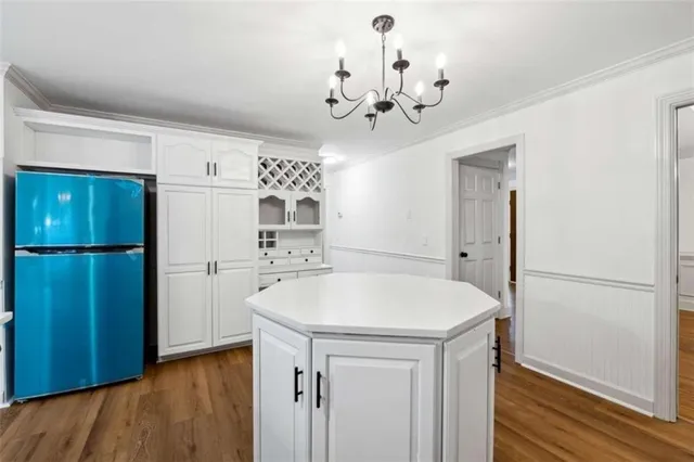 a kitchen with stainless steel appliances a refrigerator and a chandelier