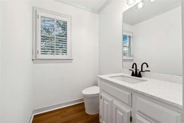 a bathroom with a sink a toilet and a window