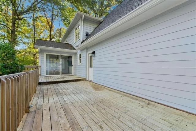 a view of backyard with wooden deck and floor to ceiling window