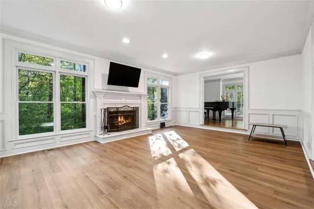 a view of empty room with wooden floor and fireplace