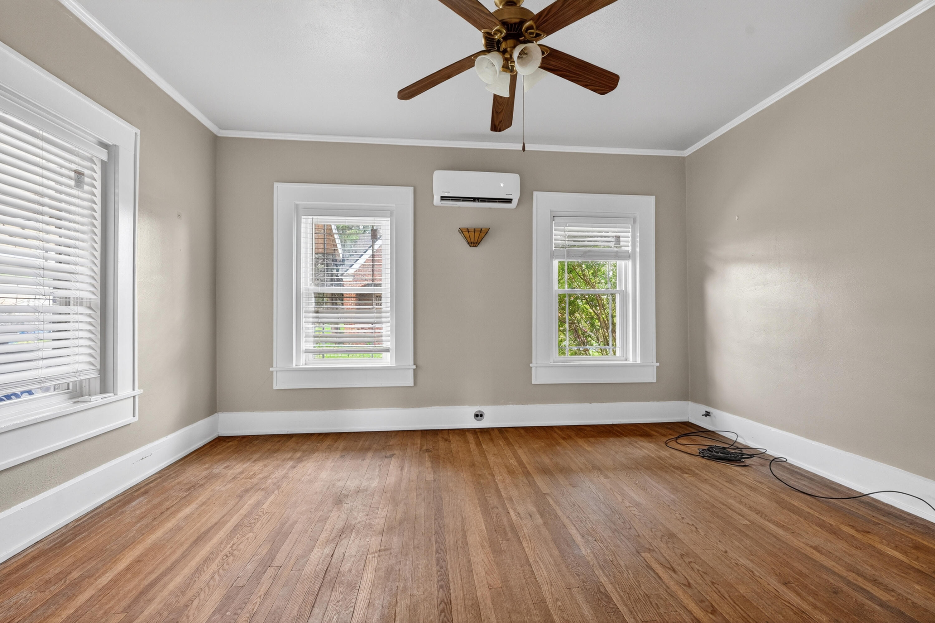 500 West Garza Street Slaton, TX 79364 - Photo 8 of 24 a view of an empty room with wooden floor and a window