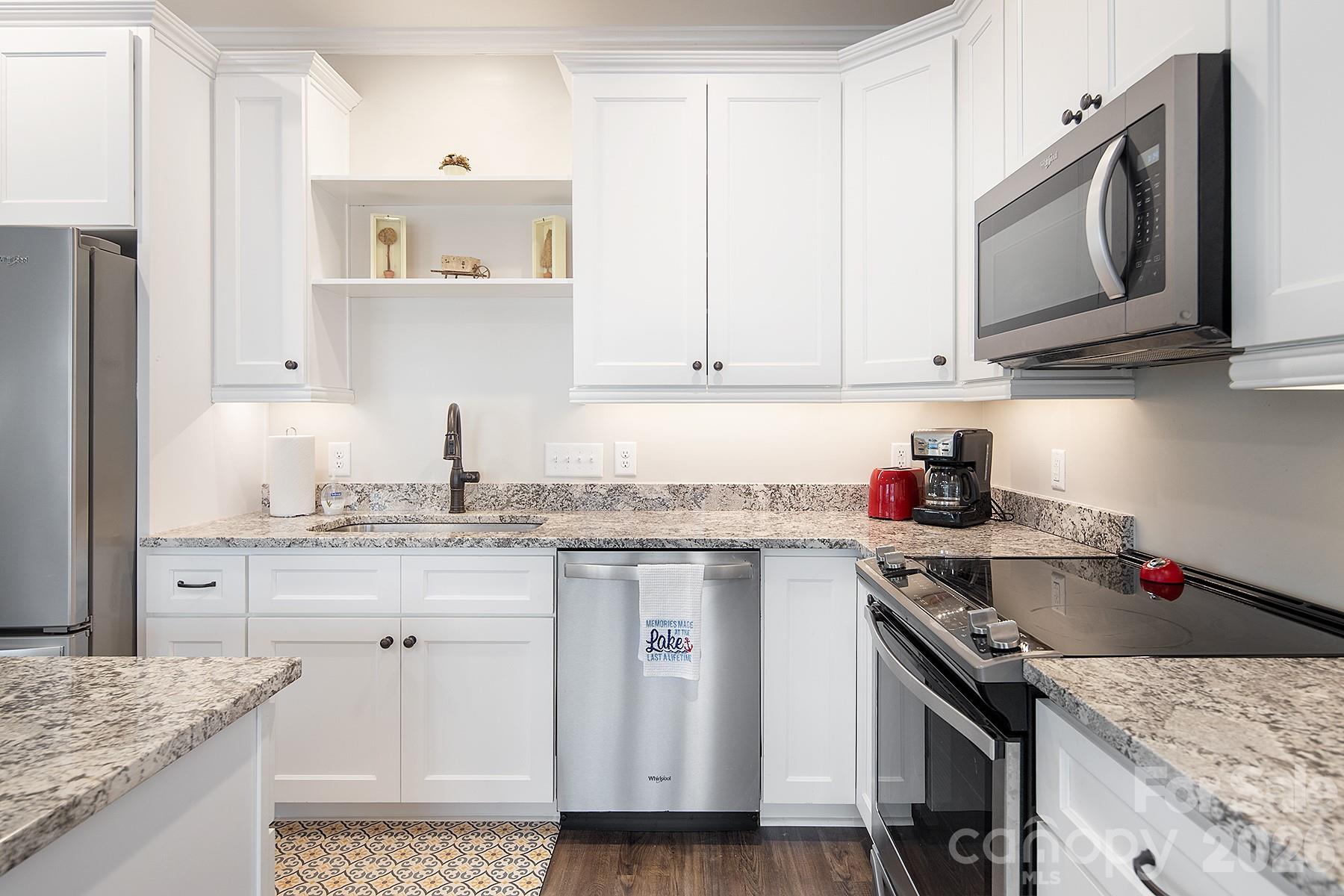 689 Emerald Shores Road Mount Gilead, NC 27306 - Photo 12 of 46 a kitchen with stainless steel appliances granite countertop a sink stove and cabinets