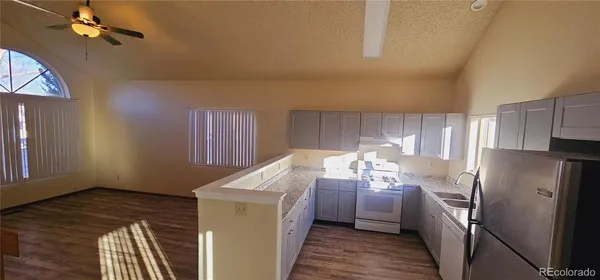a kitchen with a refrigerator sink and cabinets