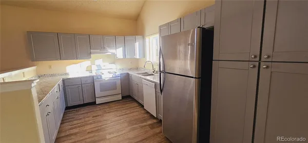 a kitchen with a refrigerator sink and cabinets