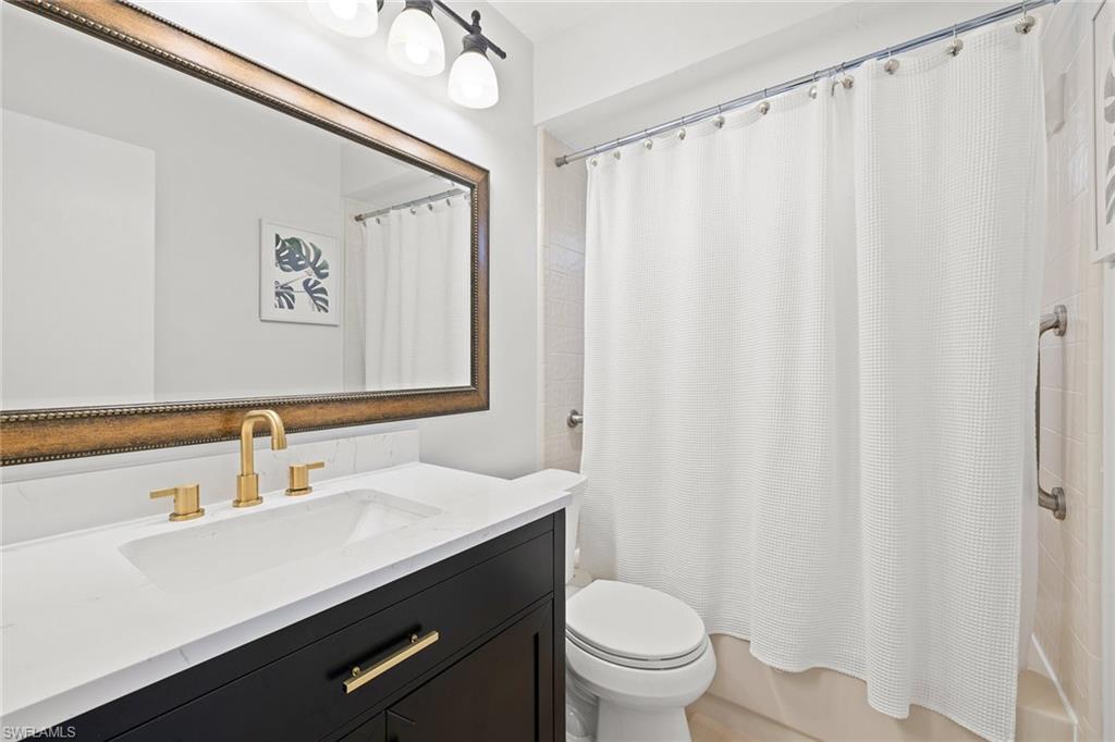 130 Torrey Pines Point Naples, FL 34113 - Photo 28 of 44 a bathroom with a sink a toilet a mirror and shower curtain