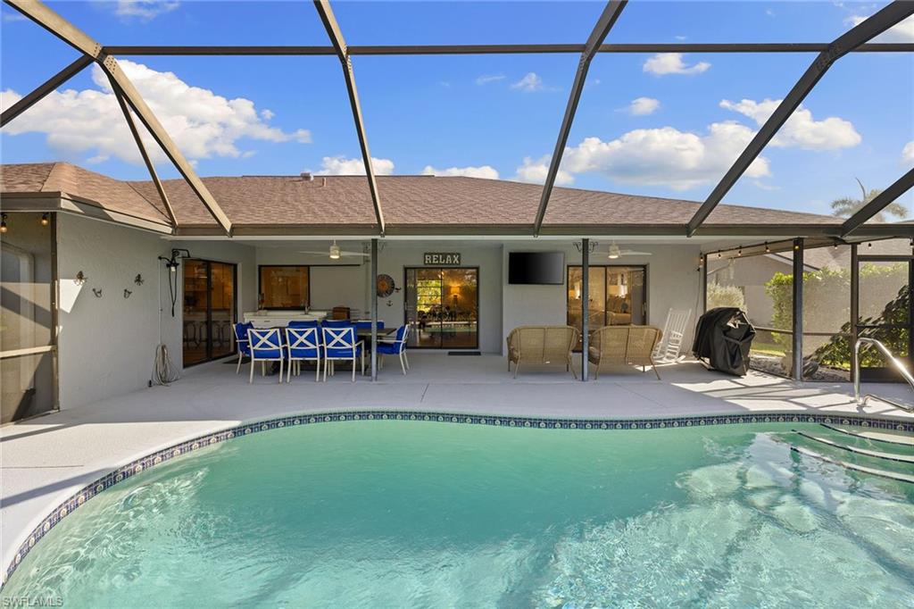 130 Torrey Pines Point Naples, FL 34113 - Photo 35 of 44 a view of a patio with table and chairs under an umbrella