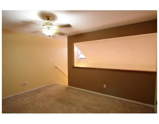 a view of an empty room and chandelier fan