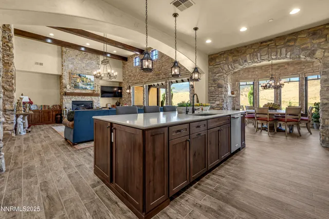 a kitchen with stainless steel appliances granite countertop a sink a stove and cabinets