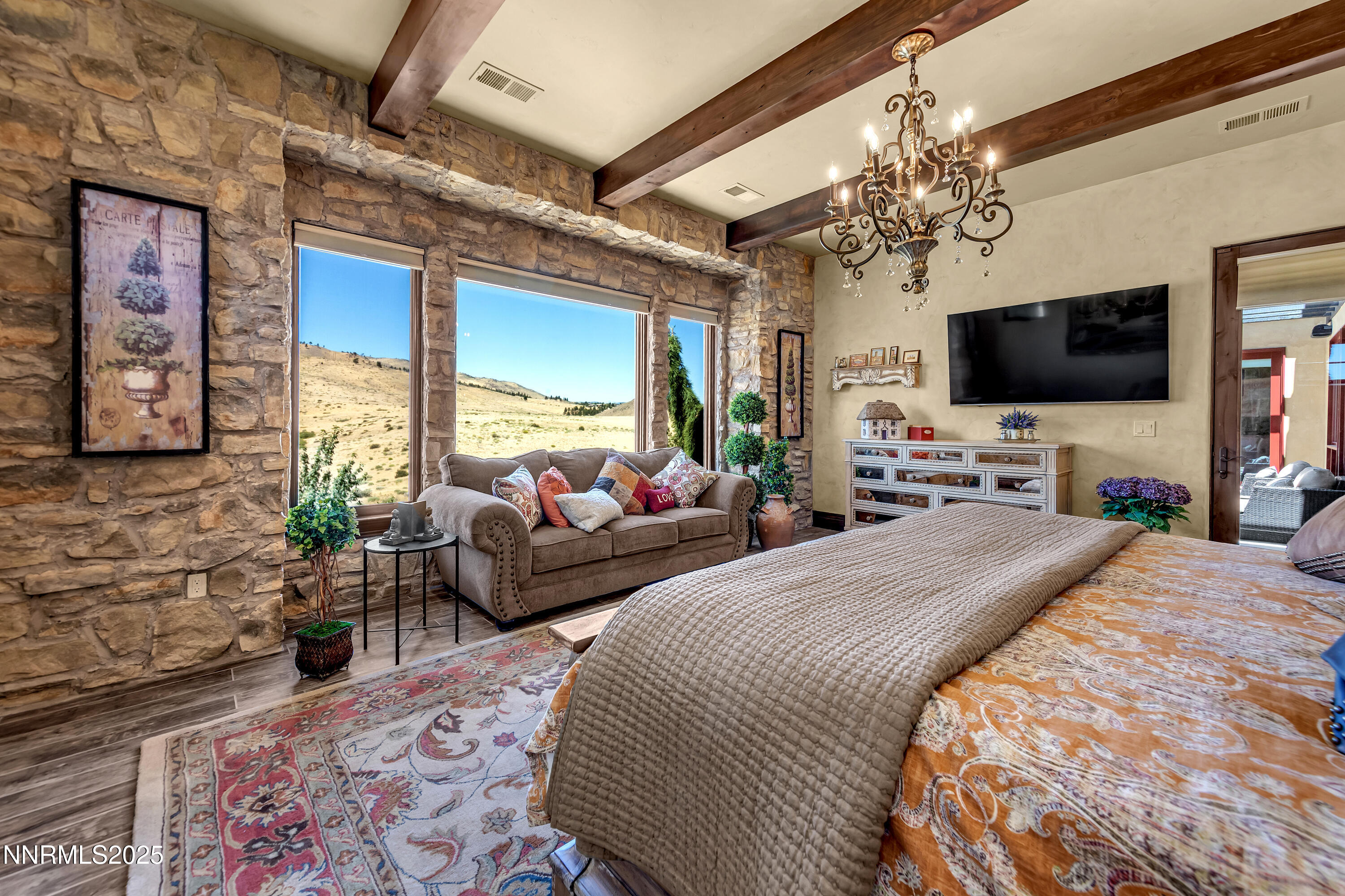 3166 Vista Favoloso Reno, NV 89519 - Photo 27 of 81 a bedroom with a bed a chandelier and a flat screen tv