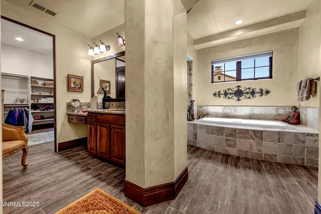 a bathroom with a granite countertop toilet sink and mirror