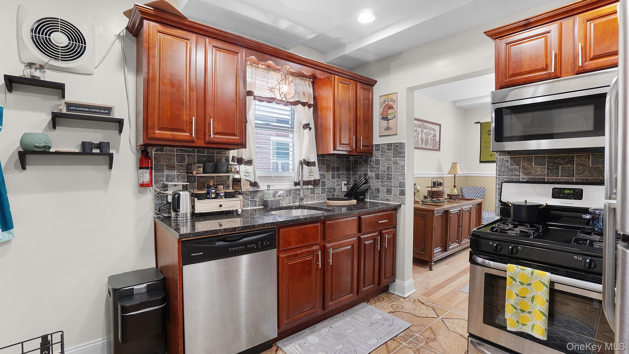 172-17 Amelia Road Queens, NY 11434 - Photo 7 of 18 a kitchen with stainless steel appliances a stove a sink and a microwave