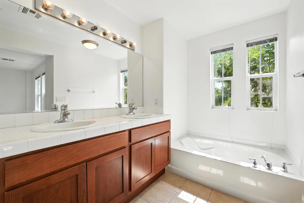 1569 Hackberry Place Chula Vista, CA 91915 - Photo 9 of 23 a bathroom with a tub a sink and a window