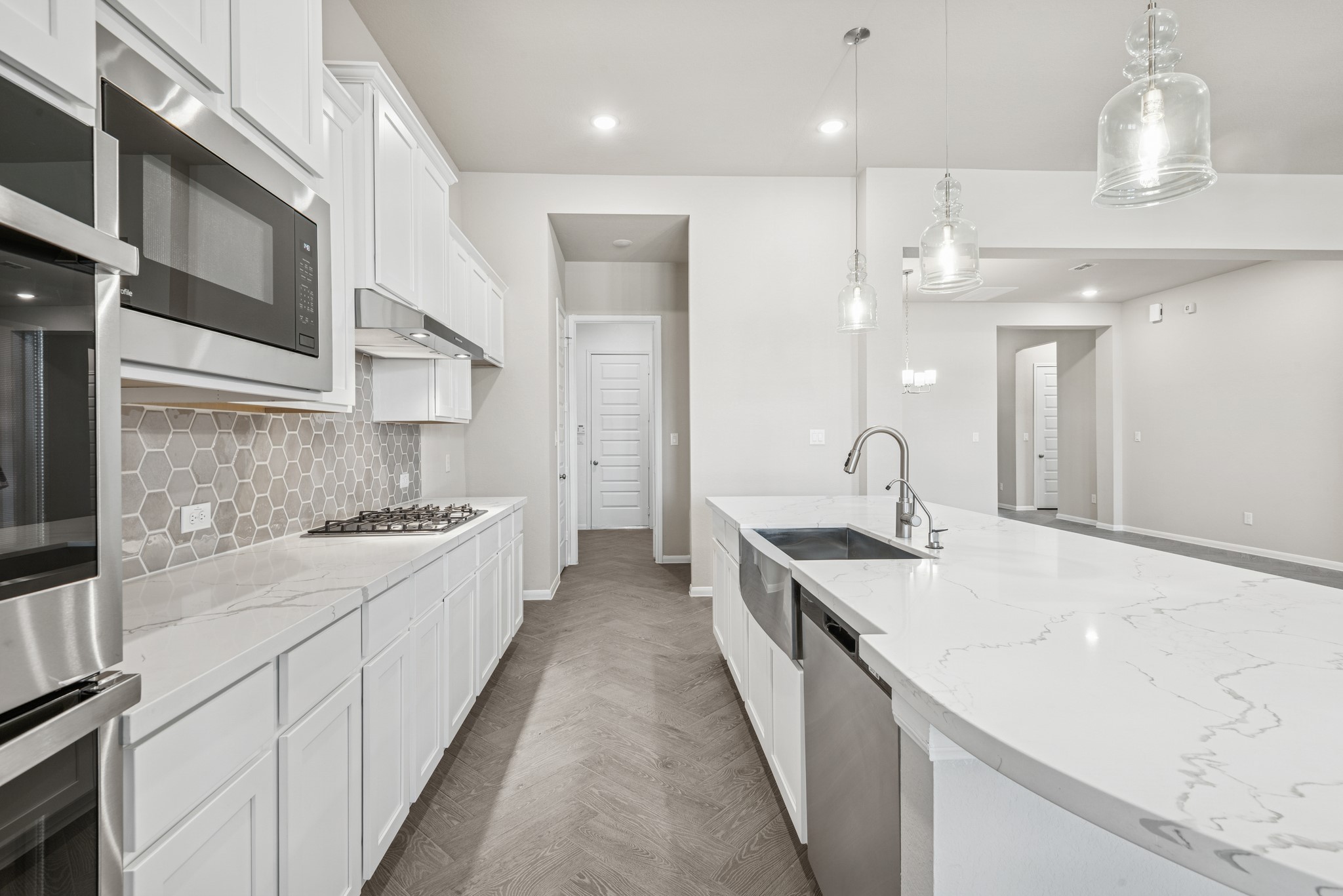 6715 Allens Landing Needville, TX 77461 - Photo 8 of 40 a large kitchen with stainless steel appliances kitchen island a large counter top a stove a chimney a sink and a refrigerator