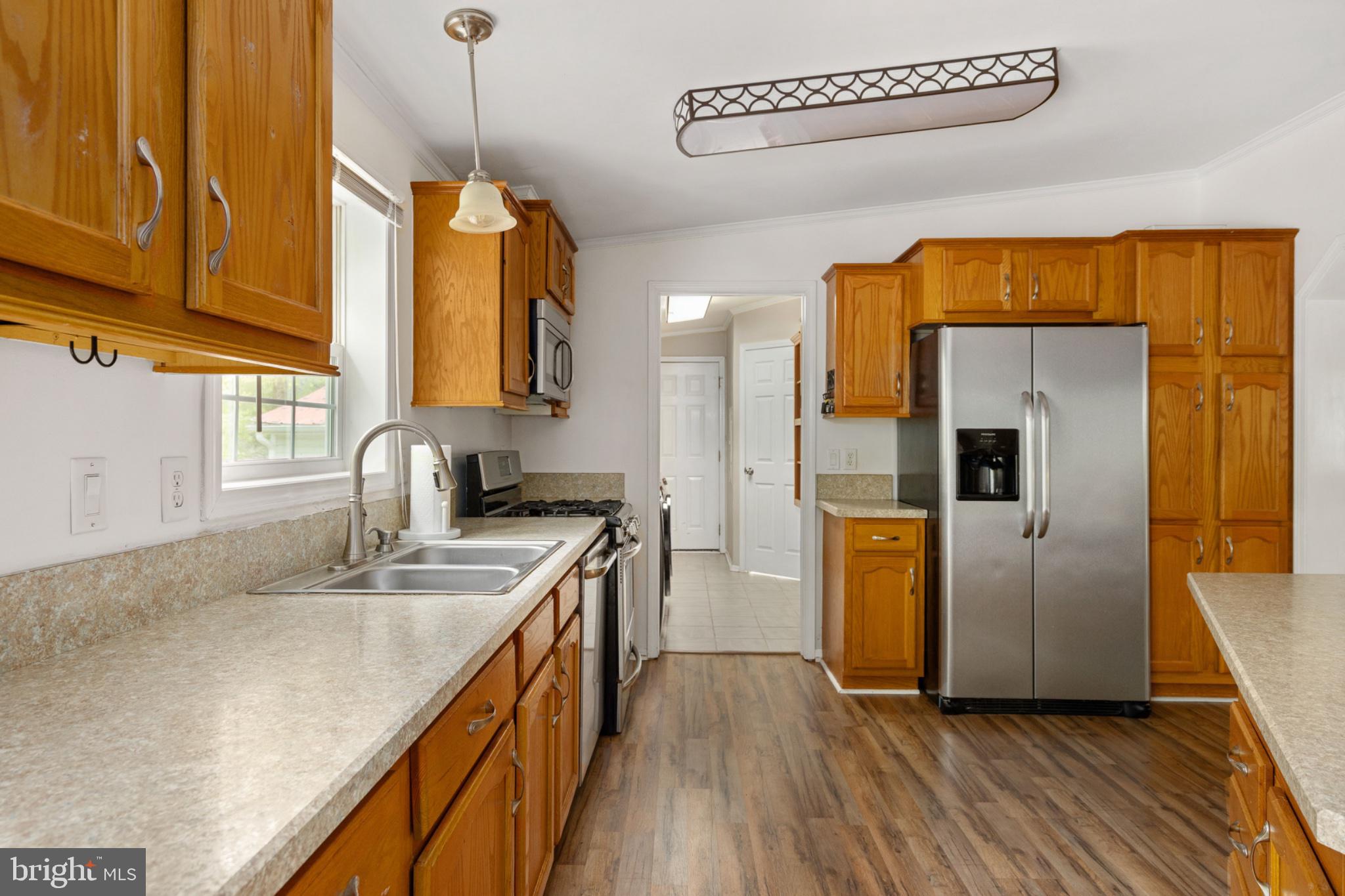 2319 Sizer Road Beaverdam, VA 23015 - Photo 31 of 61 a kitchen with stainless steel appliances granite countertop a sink a refrigerator and a wooden floor