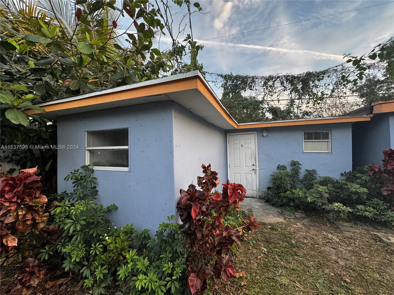 a backyard of a house with flower plants