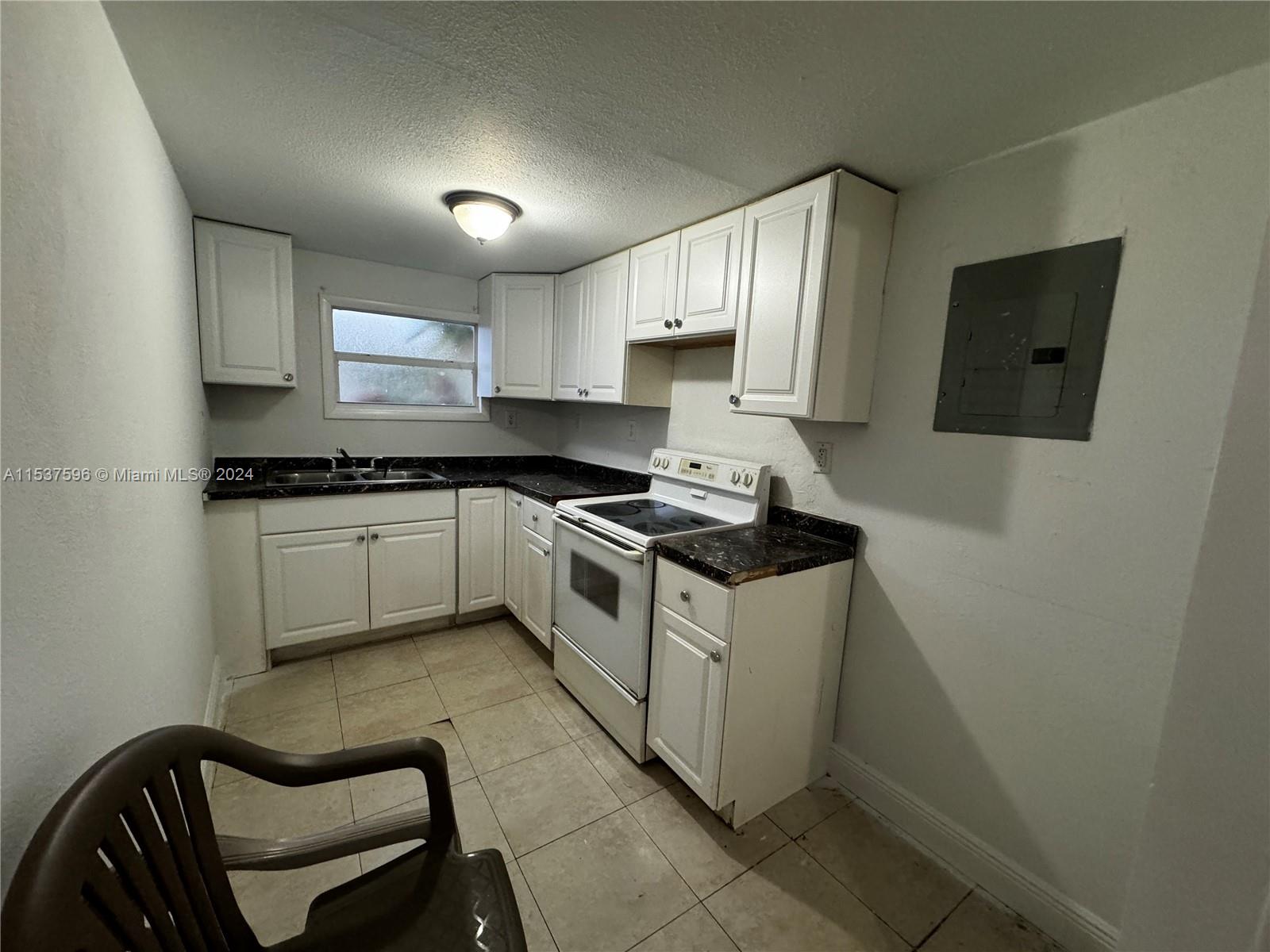 1060 Northwest 116th Street, Unit 3 Miami, FL 33168 - Photo 4 of 4 a kitchen with a sink cabinets and stainless steel appliances
