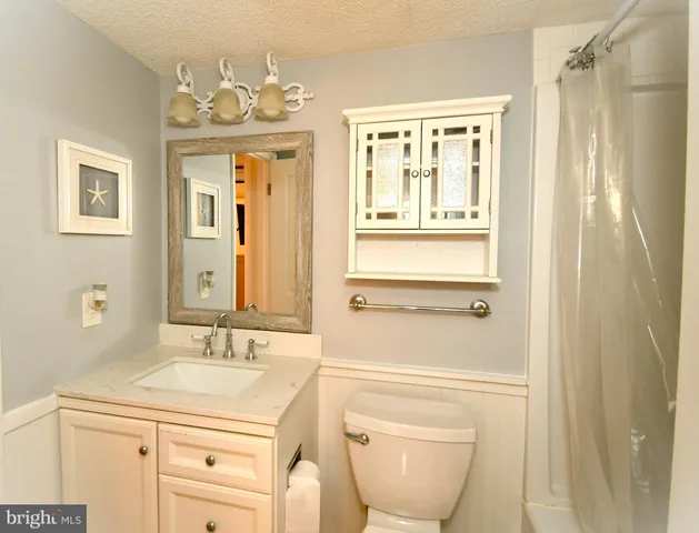 a bathroom with a granite countertop sink a mirror and a bathtub