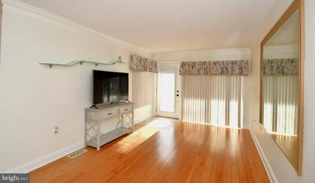 a view of a living room hardwood floor and a large window