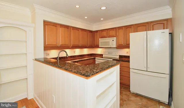 a kitchen with stainless steel appliances granite countertop a refrigerator sink and cabinets